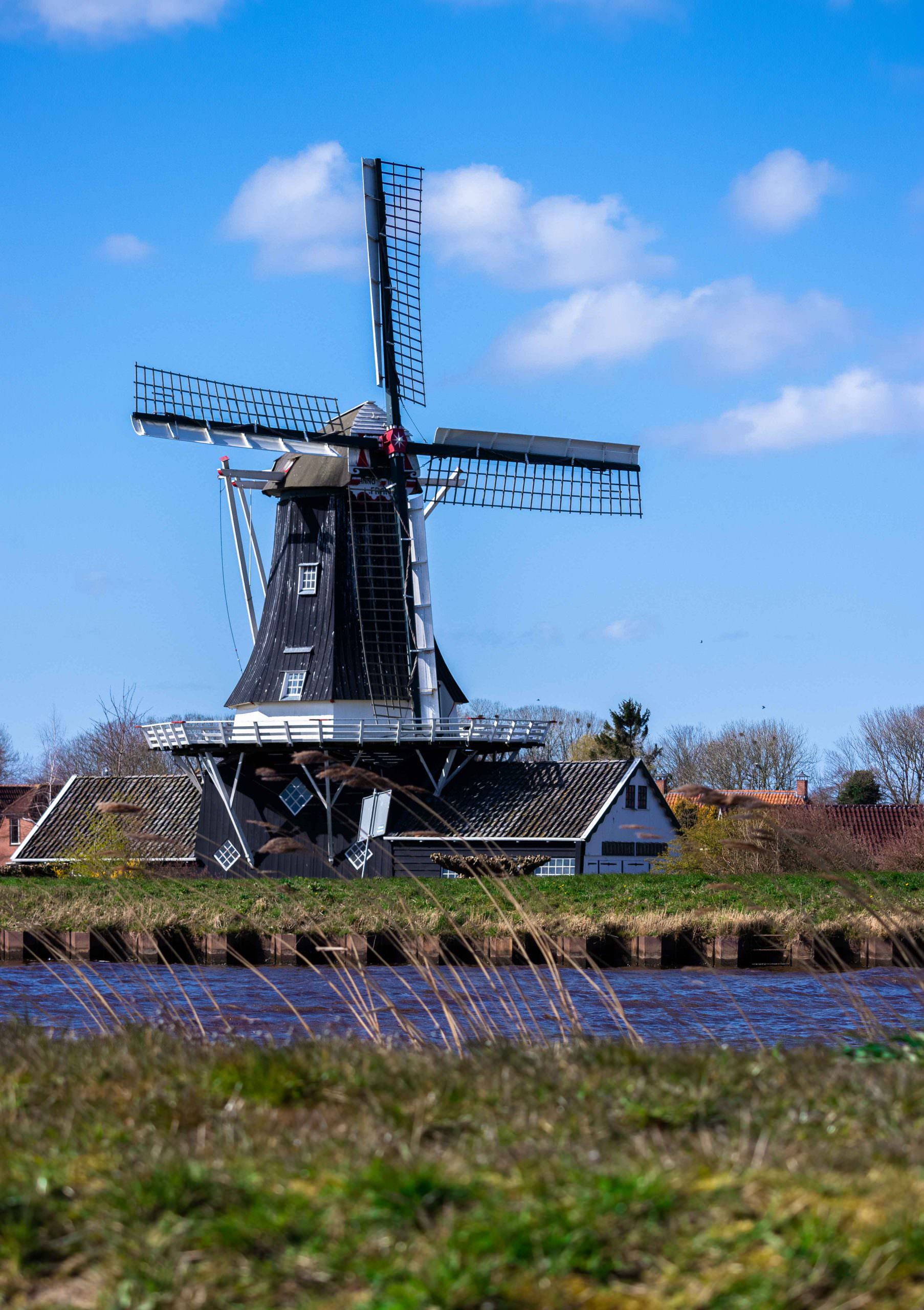 dutch windmill with water and blue sky